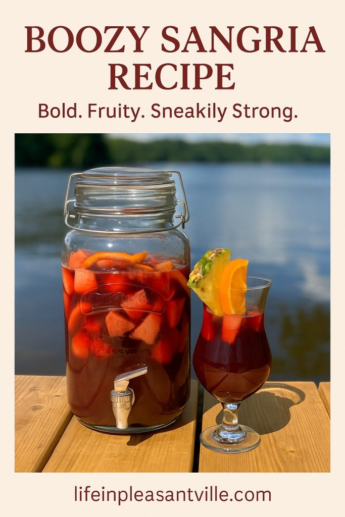Pinterest graphic featuring a photo of a sangria dispenser and glass on a dock with the text "Boozy Sangria Recipe – Bold. Fruity. Sneakily Strong." and the URL lifeinpleasantville.com.