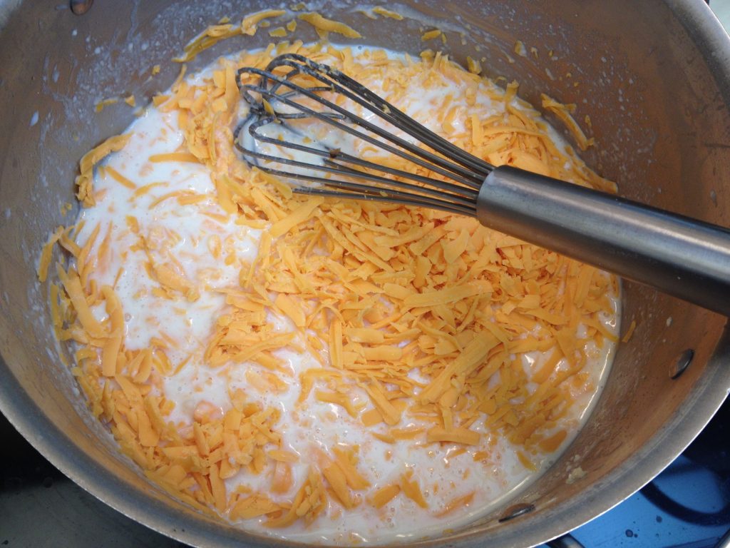 mac and  cheese, milk and cheese mixture on stove