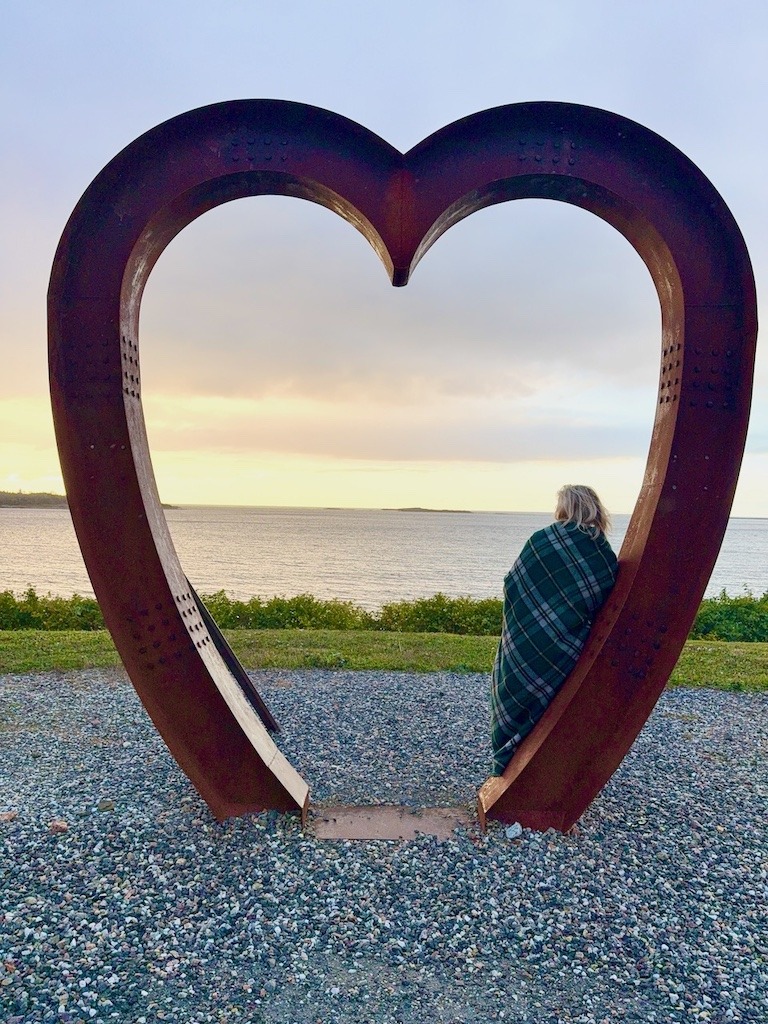A woman stands under the heart at North Star in Louisbourg Nova Scotia