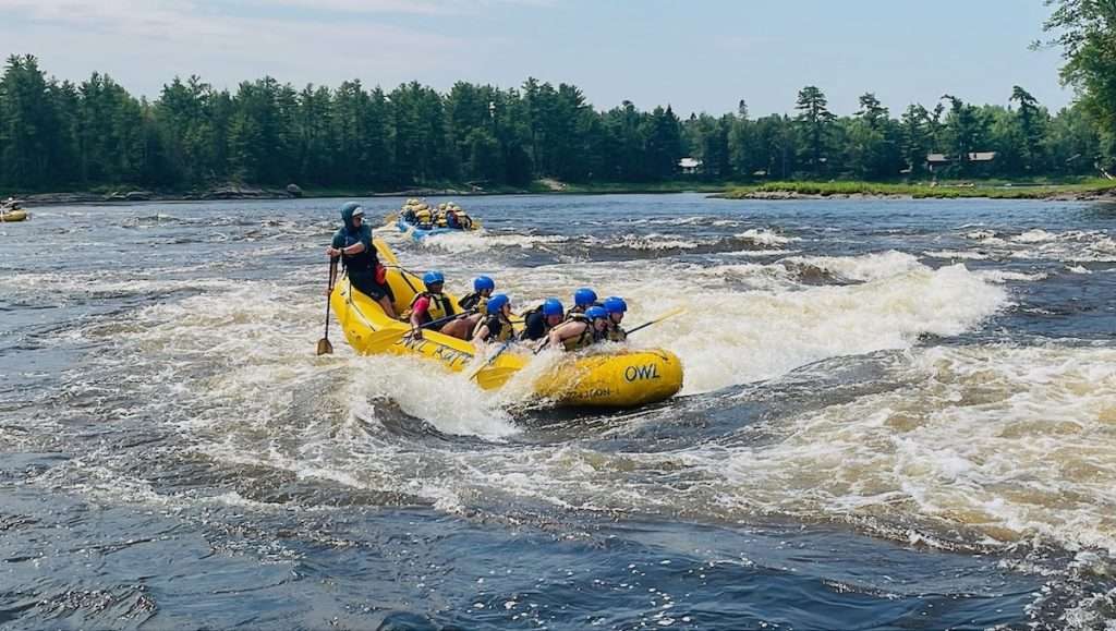 An OWL Rafting boat and crew paddling through white water rapids on the Ottawa River in Ontario