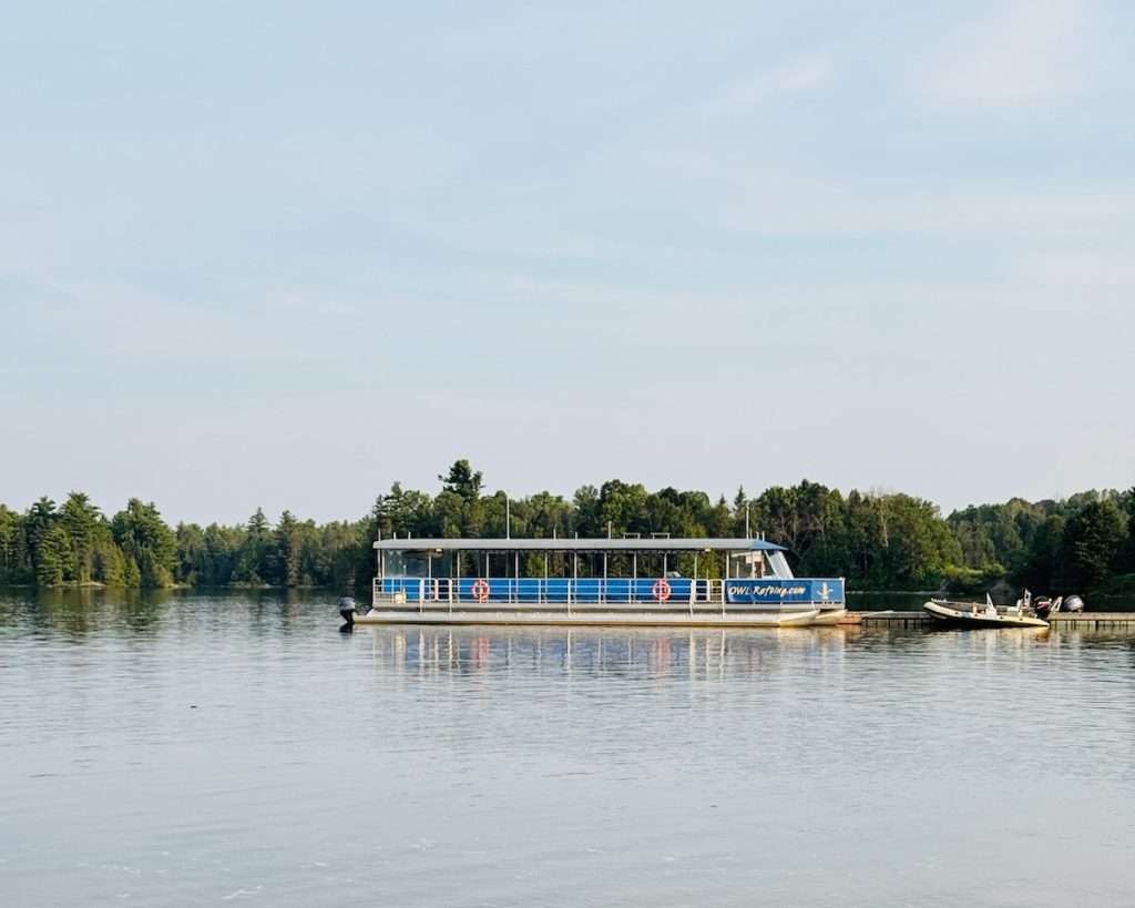 The OWL Rafting pontoon boat moored on the calm Ottawa River, where the floating barbecue meal is served after rafting