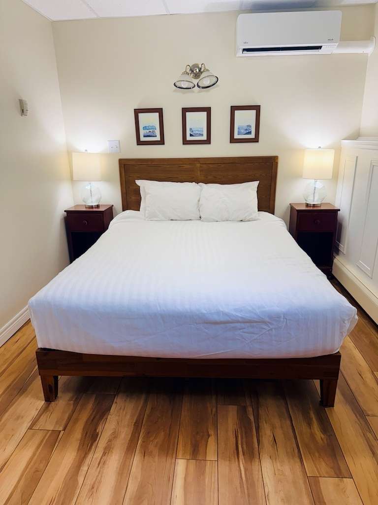 where to stay celtic colours Guest room at Mabou River Inn Cape Breton with hardwood floors and queen bed