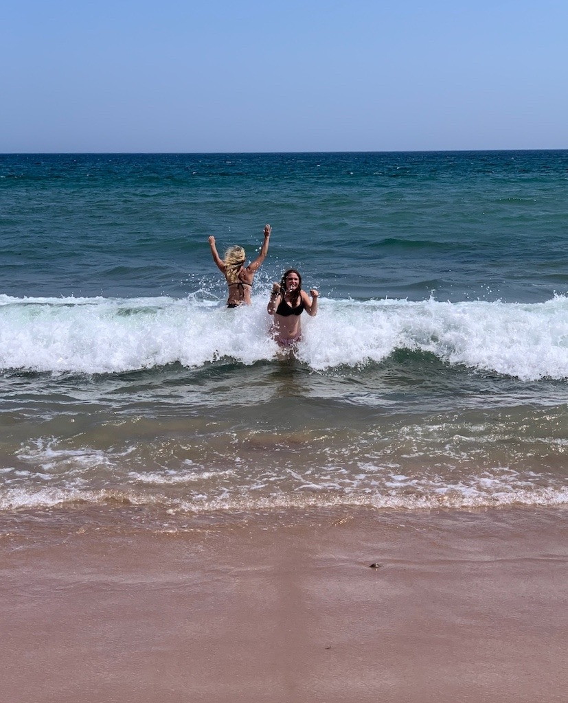 Two woman splashing in the water at Ingonish Beach off Cape Breton Island.