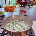 Basil in warm milk for infusion in strawberry ice cream.