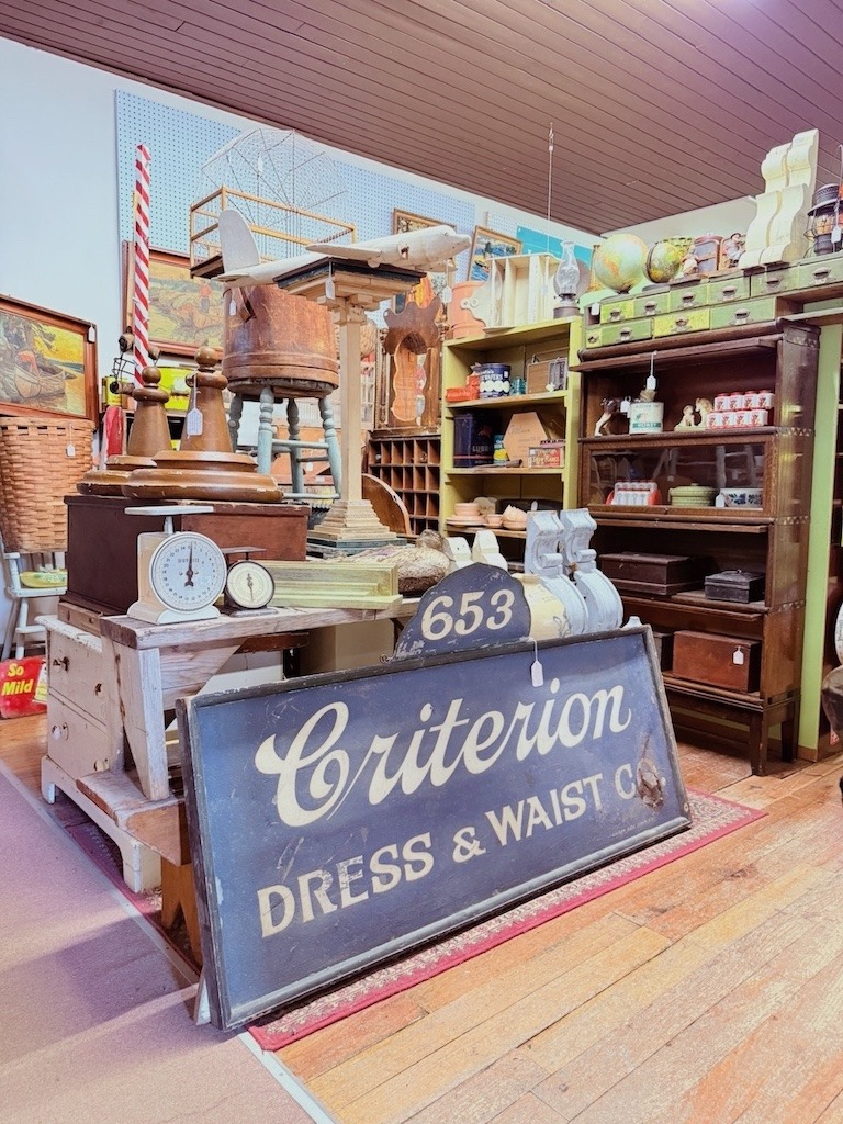 Vintage Criterion Dress & Waist Co. sign among antiques inside Almonte Antiques and Collectibles.