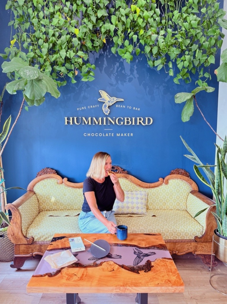 Woman enjoying chocolate and coffee inside Hummingbird Chocolate Maker.