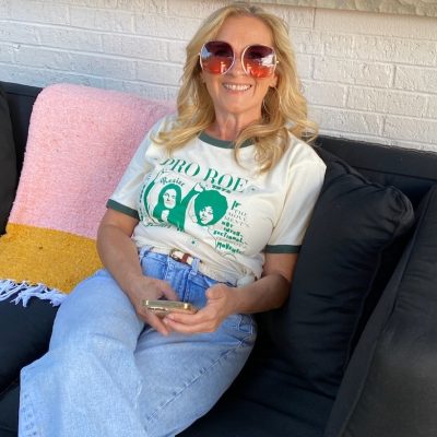 Gen X woman smiling in a Pro Roe t-shirt, done being angry and choosing joy instead