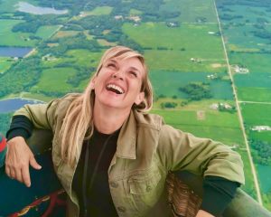 a feature image for an article about extinction of experience where a woman is experiencing pure joy in a hot air balloon