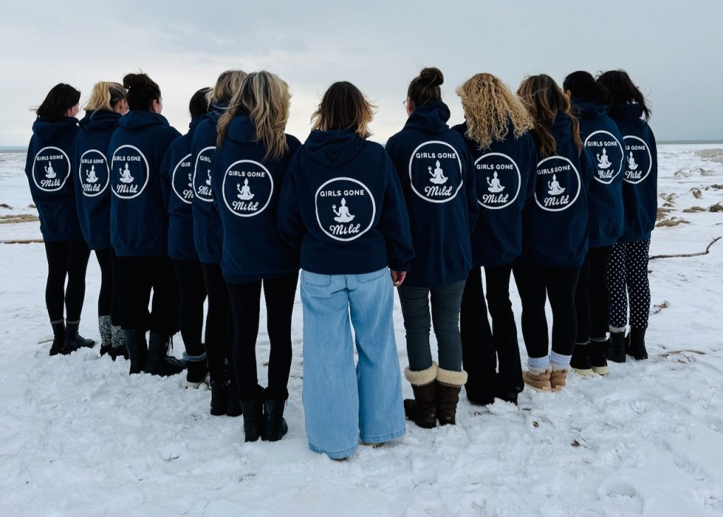 Girls Gone Mild group wearing matching navy hoodies on snowy Crystal Beach Ontario in winter