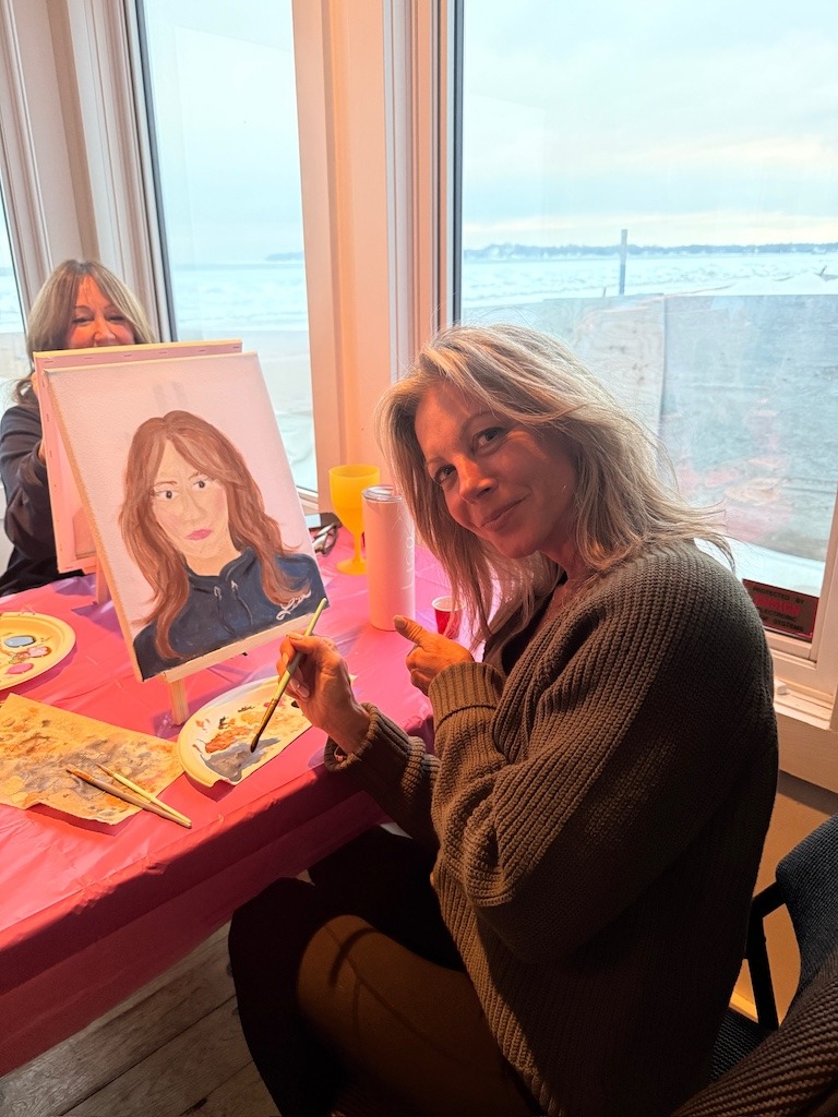 Friend painting a detailed portrait during a Crystal Beach Ontario winter girls weekend paint night
