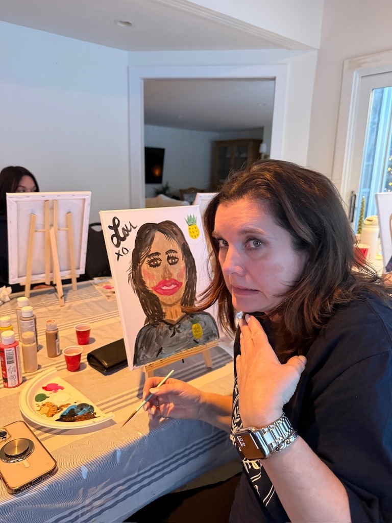 Friend painting a humorous portrait during winter girls weekend in Crystal Beach Ontario