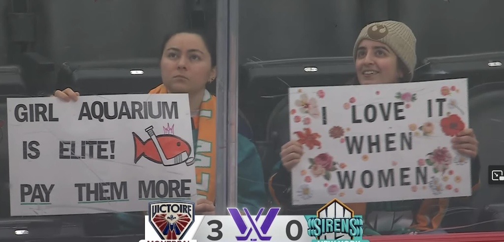 PWHL fans holding signs supporting women's hockey