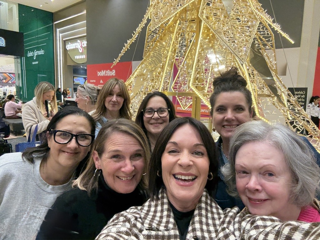 group of women laughing together on a holiday shopping trip