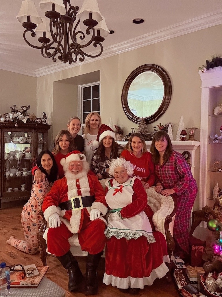 Women celebrating at a Girl Trips Christmas retreat with Santa and Mrs. Claus