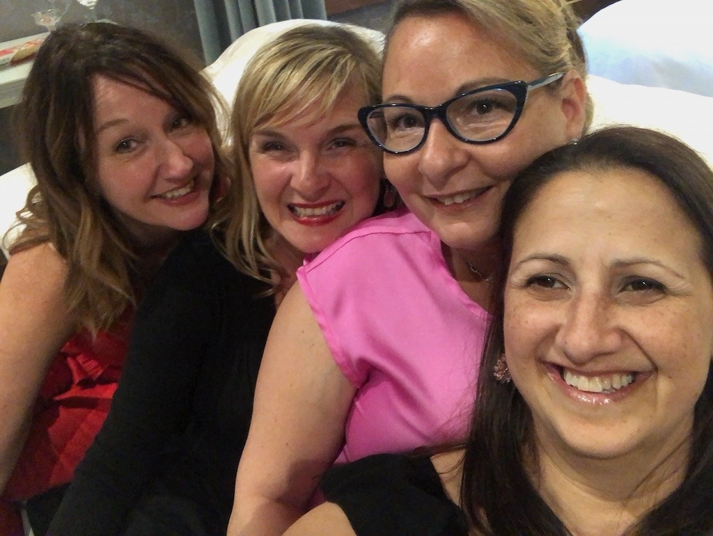 Four women friends laughing together on a girls weekend away