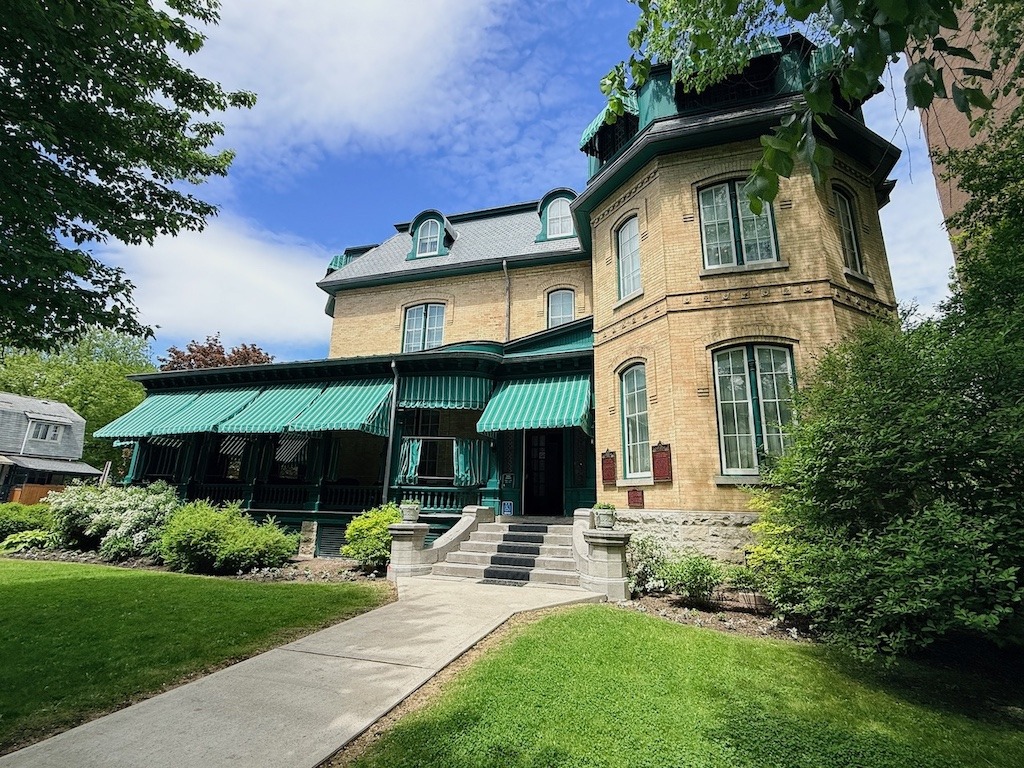  Laurier House Ottawa exterior with hunter green striped awnings and yellow brick Second Empire facade