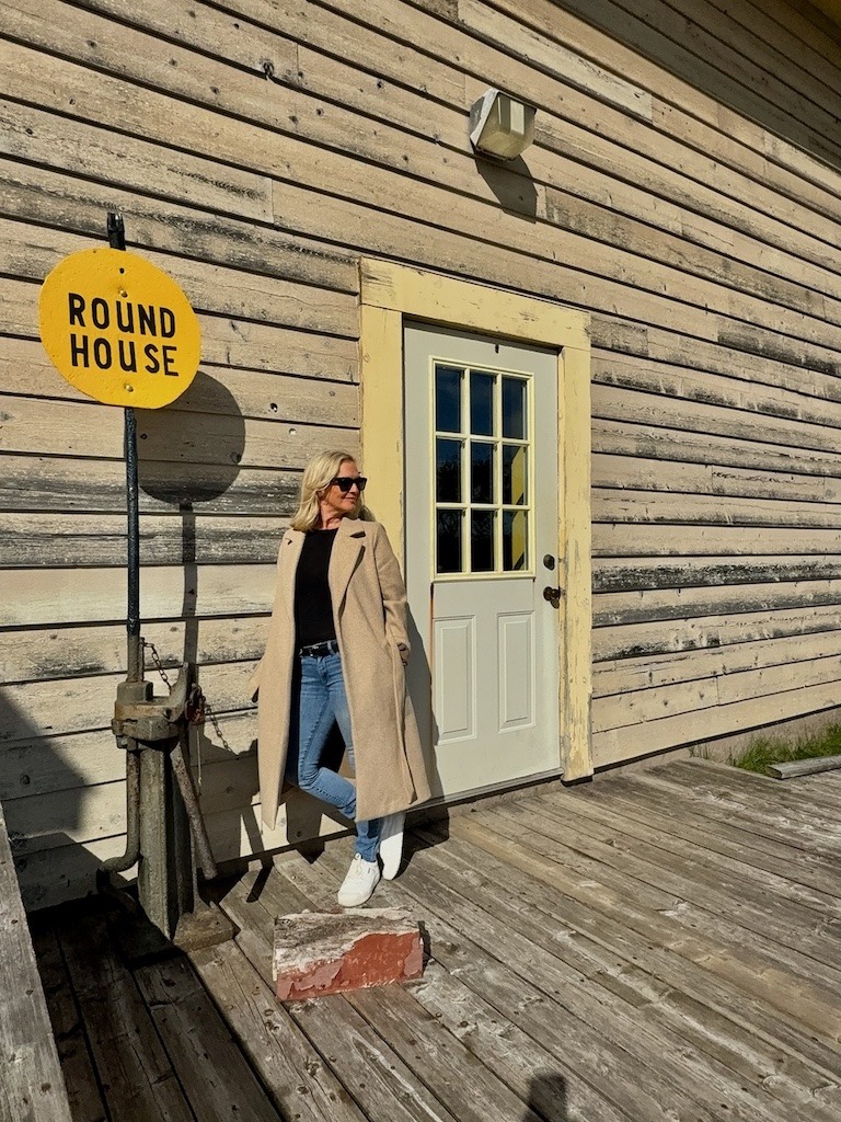 A woman stands outside at the Sydney and Louisbourg Railway Museum