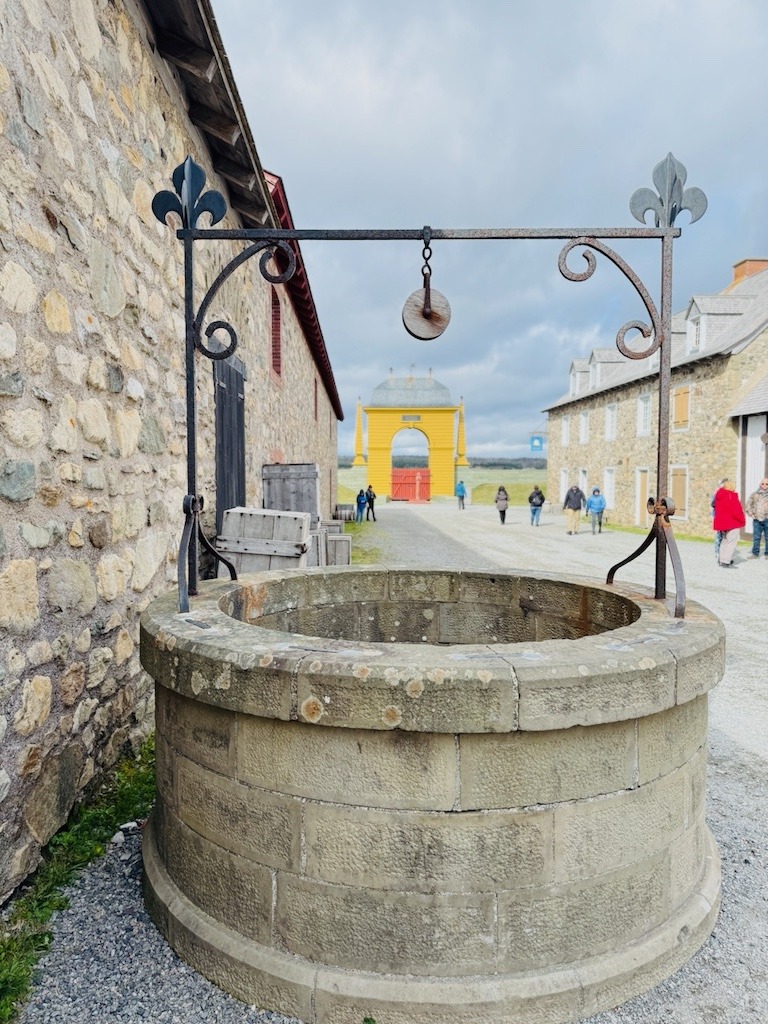 Stone well inside the Fortress of Louisbourg with the King's Gate in the background