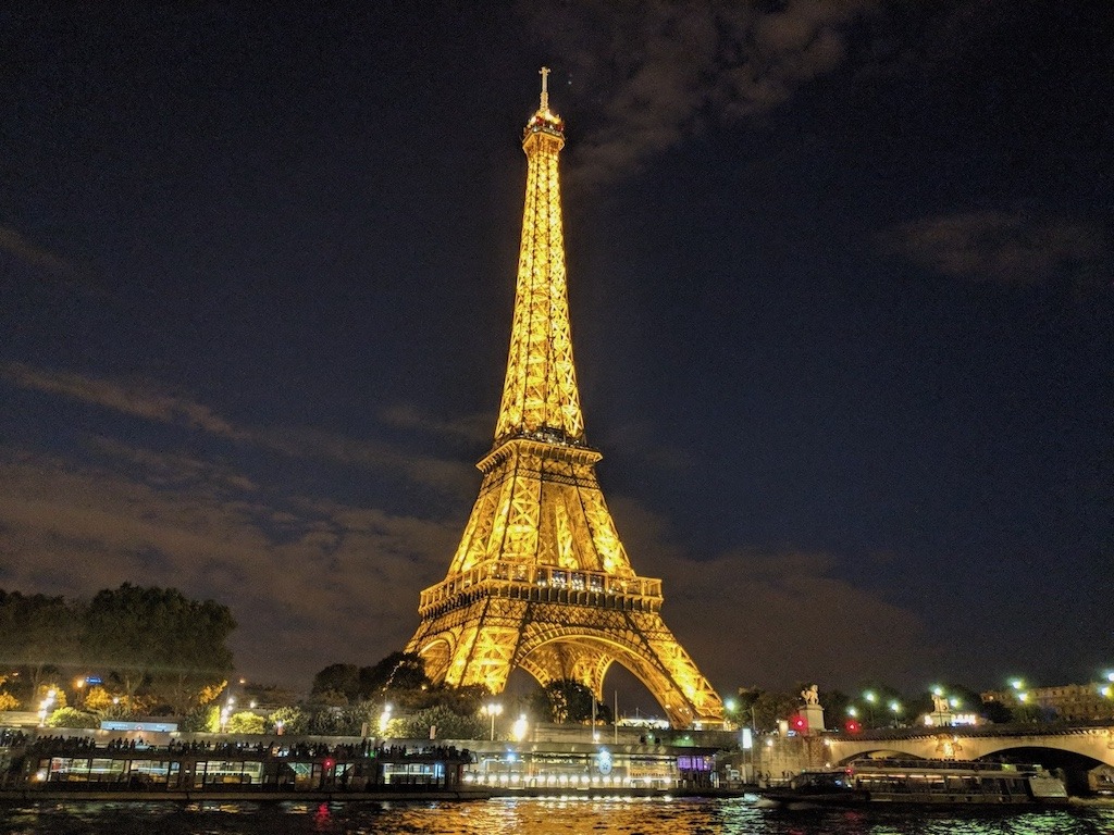 Eiffel Tower illuminated at night reflected in the Seine River Paris France, can travel heal a broken heart