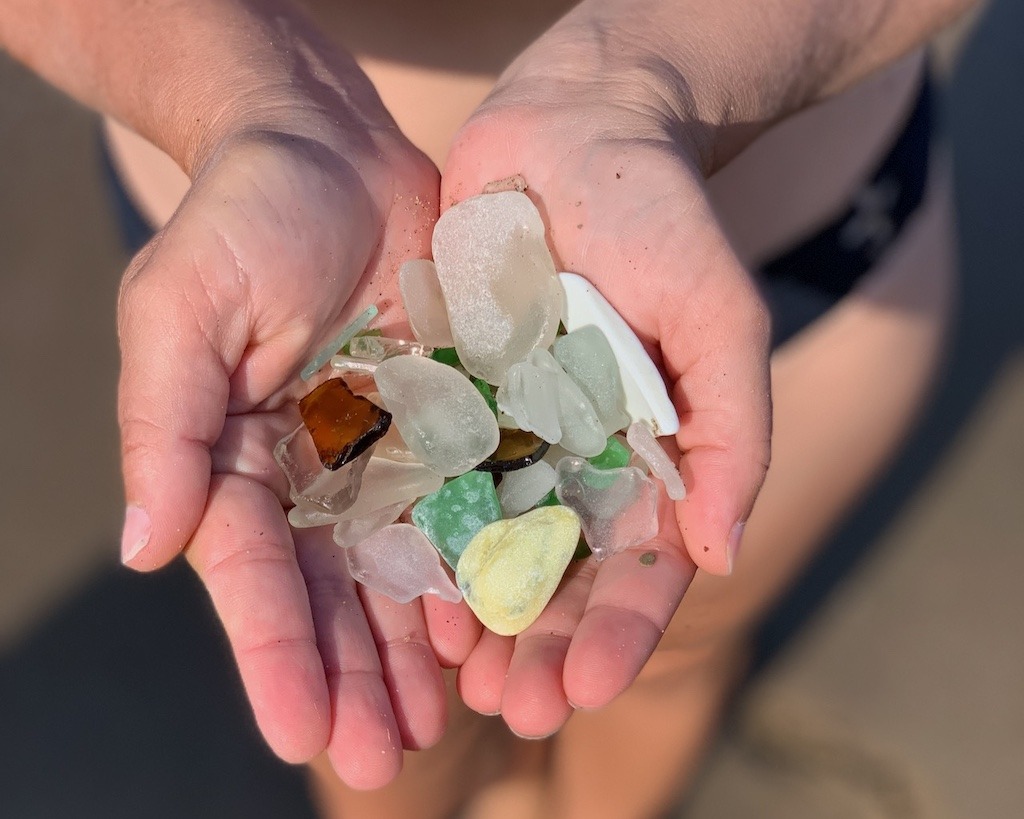 Sea glass Cape Breton haul held over the shoreline at Florence Beach