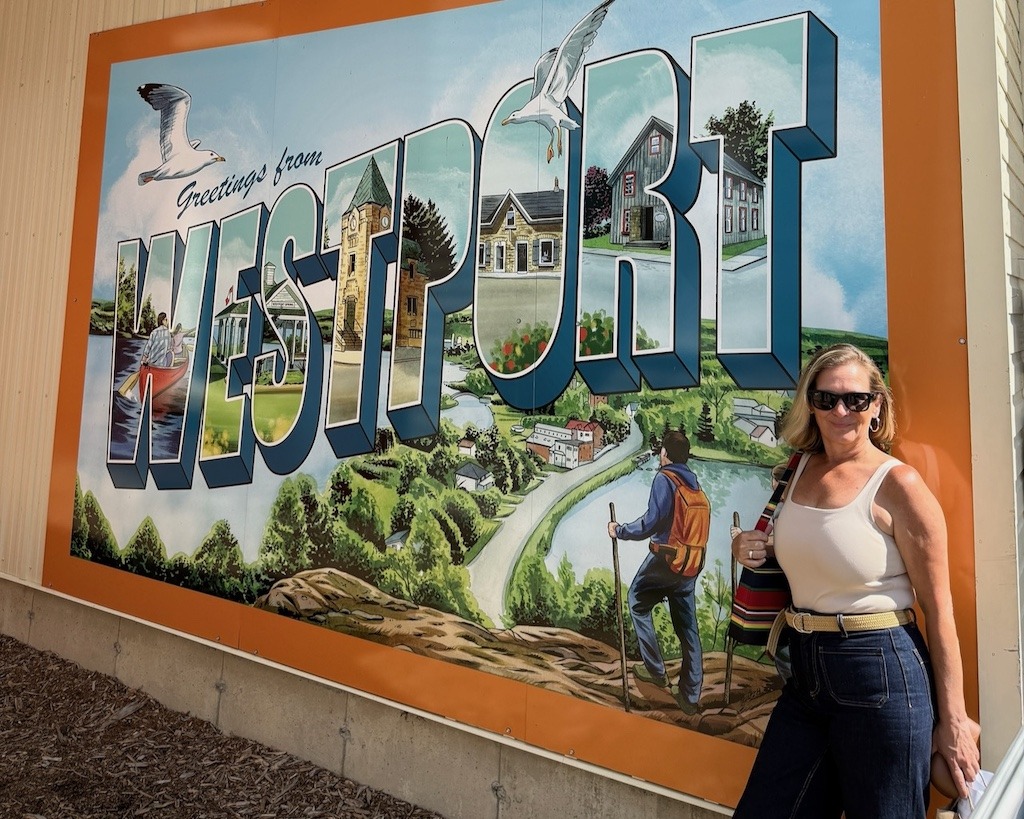 why travel blogs are so positive - Candace Sampson at Greetings from Westport mural Ontario