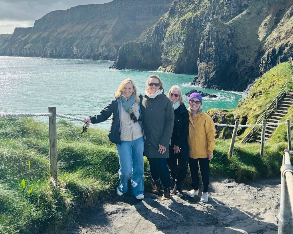 why travel blogs are so positive - four women laughing on the cliffs of Ireland